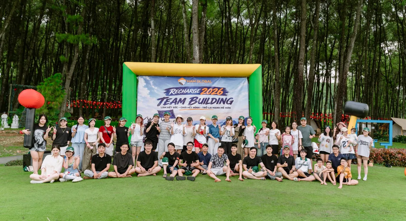 The HAM Global team posing outdoors in a pine forest at the Recharge 2026 team building event