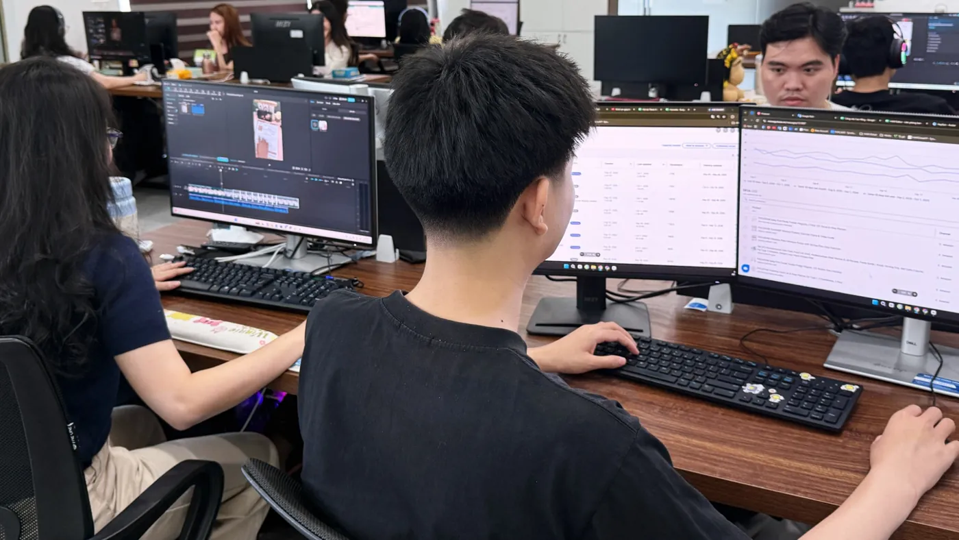 A team member reviewing sales charts and reports across two monitors