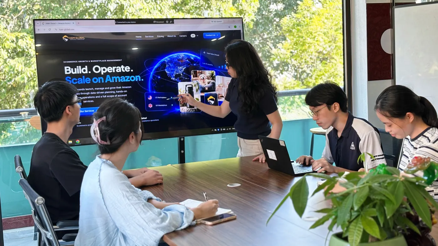 A team member presenting the HAM Global website on a large screen to colleagues in a meeting room